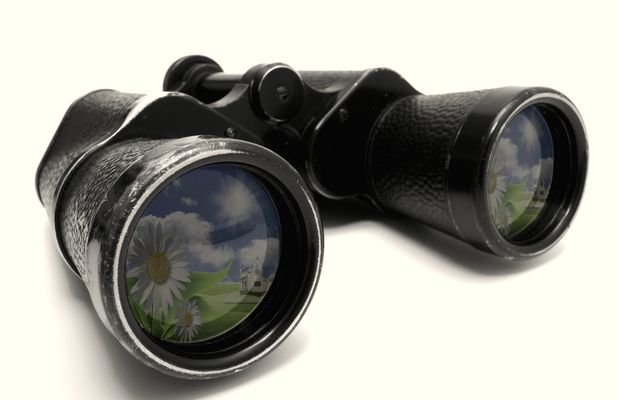 A pair of old binoculars on a white surface
