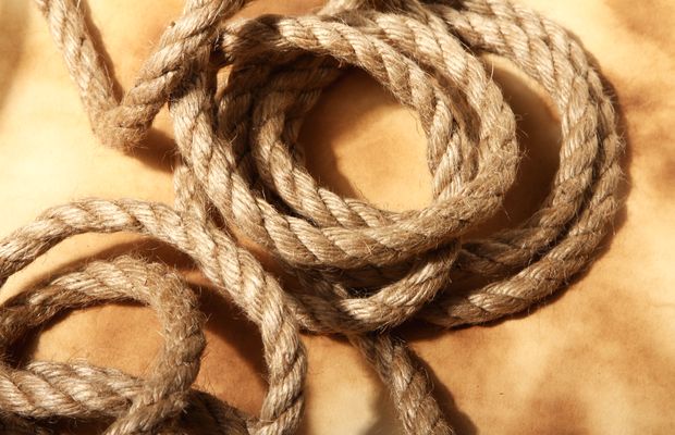 A coil of old twisted fiber rope on aged paper