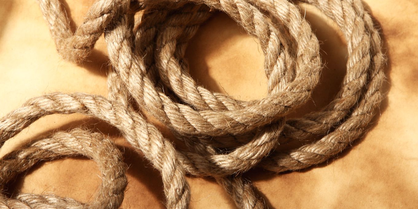 A coil of old twisted fiber rope on aged paper
