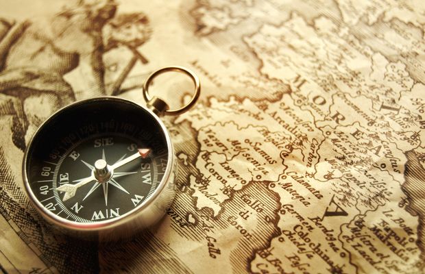 A pocket compass lying open on an old printed map