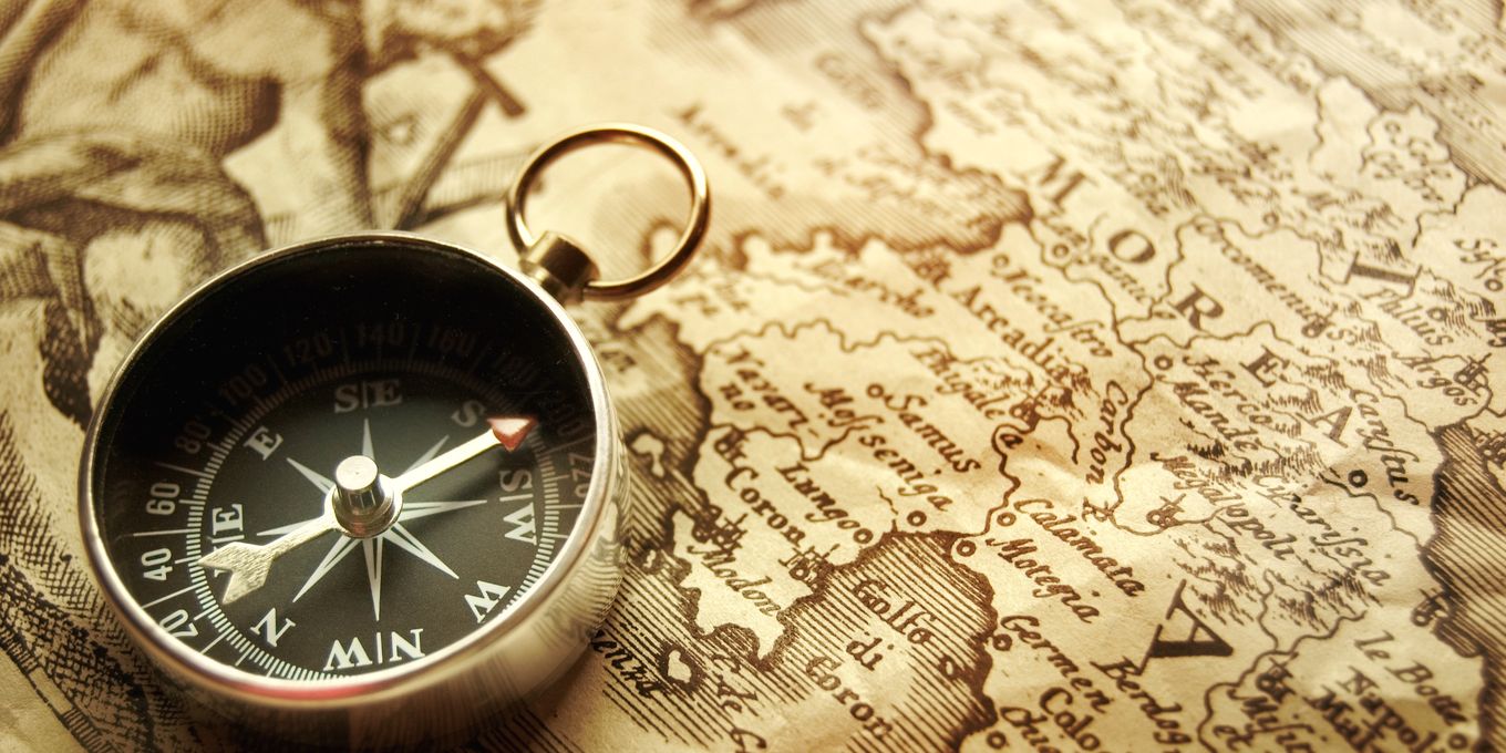 A pocket compass lying open on an old printed map