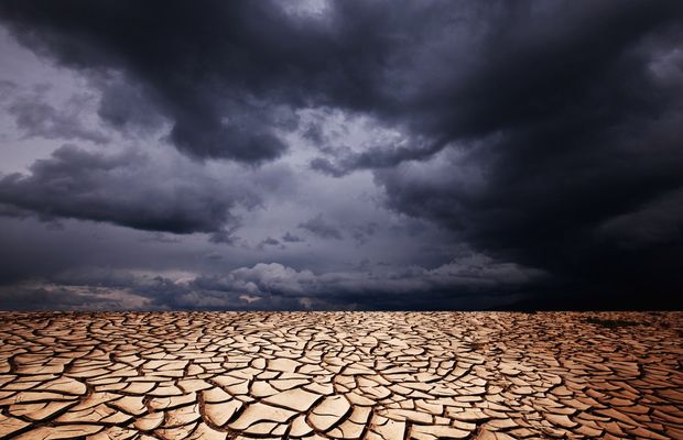 Dark storm clouds over dry, cracked ground