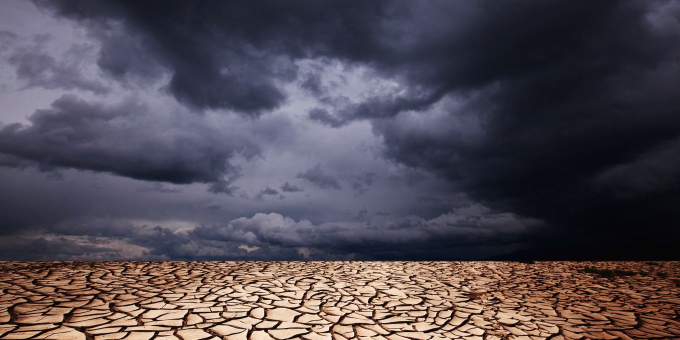 Dark storm clouds over dry, cracked ground