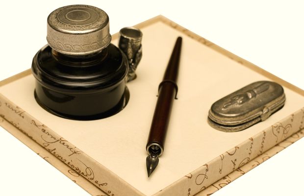 A dip pen and an inkwell on a writing box