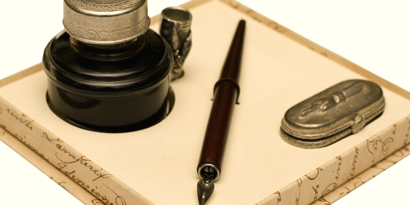A dip pen and an inkwell on a writing box