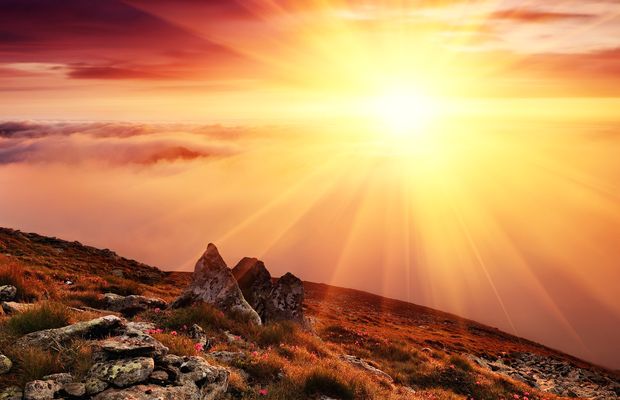 The sun low over a rocky slope and a long ridge
