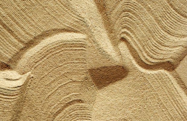 Wind-shaped ripples and grooves in pale sand